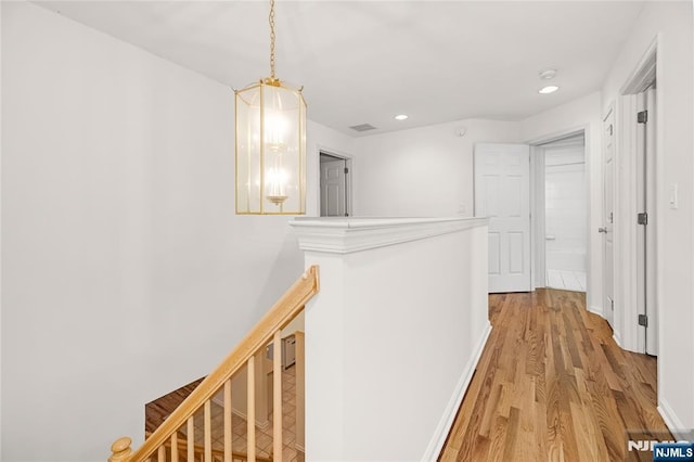 corridor with recessed lighting, an upstairs landing, light wood-type flooring, and baseboards