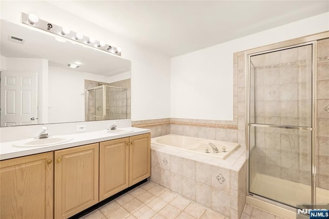 bathroom with visible vents, a stall shower, a garden tub, and a sink