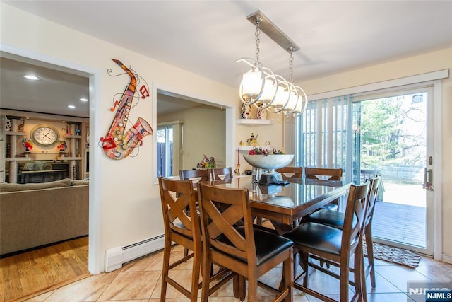 dining room with light tile patterned floors, a baseboard heating unit, and plenty of natural light