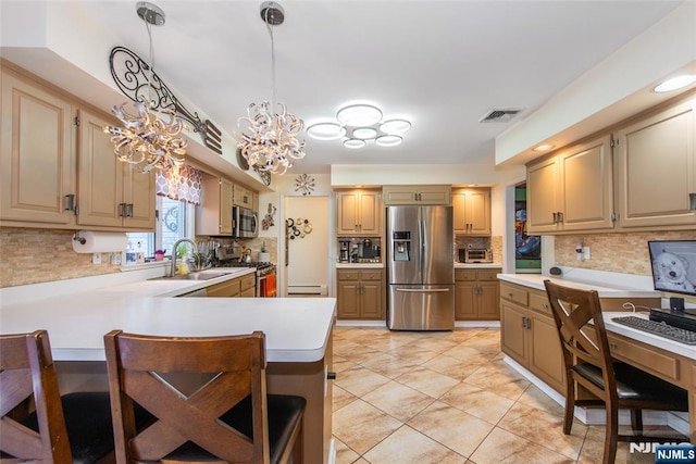 kitchen featuring visible vents, a breakfast bar area, baseboard heating, stainless steel appliances, and a sink