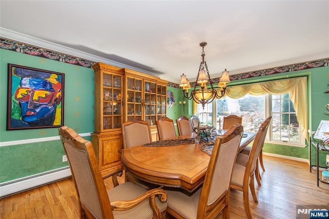 dining area featuring baseboards, light wood finished floors, a baseboard radiator, crown molding, and a notable chandelier