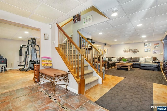 stairway featuring recessed lighting, a paneled ceiling, and baseboards