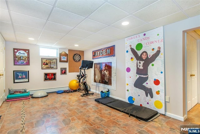 exercise area with recessed lighting, a baseboard heating unit, a paneled ceiling, and baseboards