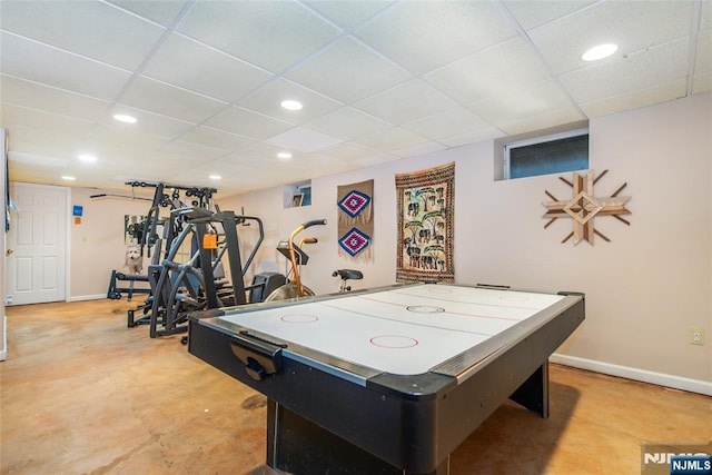 game room featuring recessed lighting, a paneled ceiling, baseboards, and concrete floors