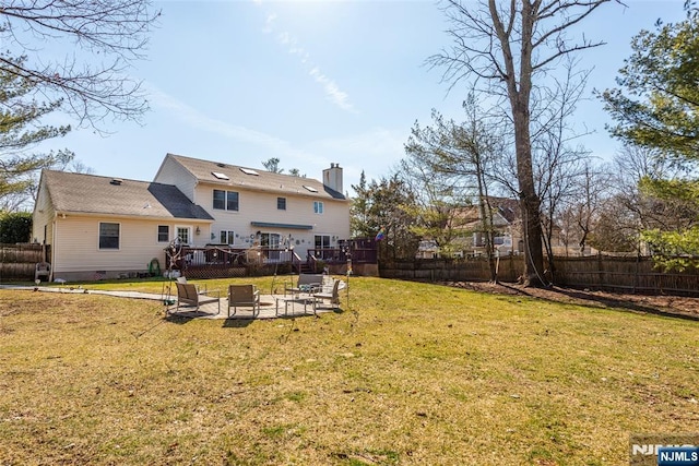 view of yard featuring a fenced backyard, a patio, a fire pit, and a deck