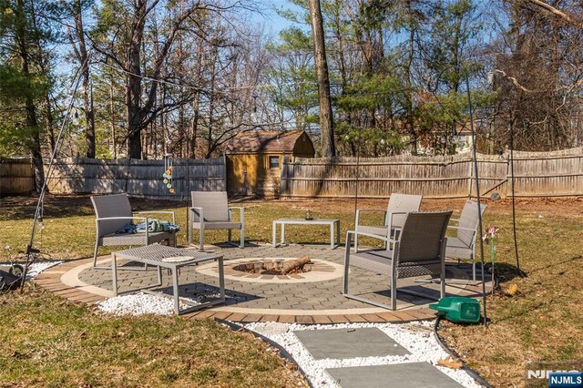 view of yard featuring a patio, an outdoor fire pit, and a fenced backyard