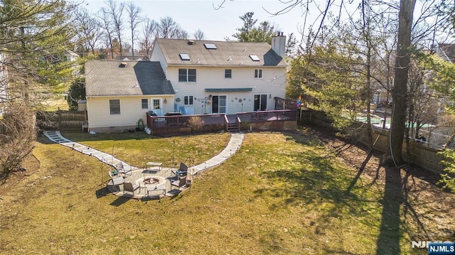 rear view of house featuring a lawn, a fenced backyard, an outdoor fire pit, a wooden deck, and a chimney