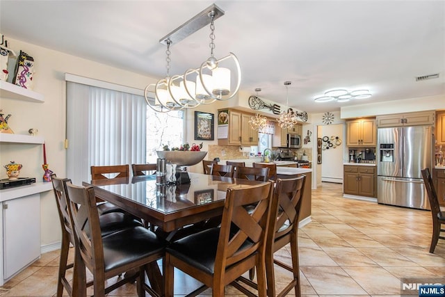 dining space with light tile patterned floors and visible vents