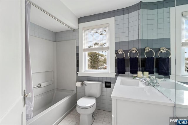 full bath featuring tub / shower combination, toilet, vanity, tile patterned floors, and tile walls