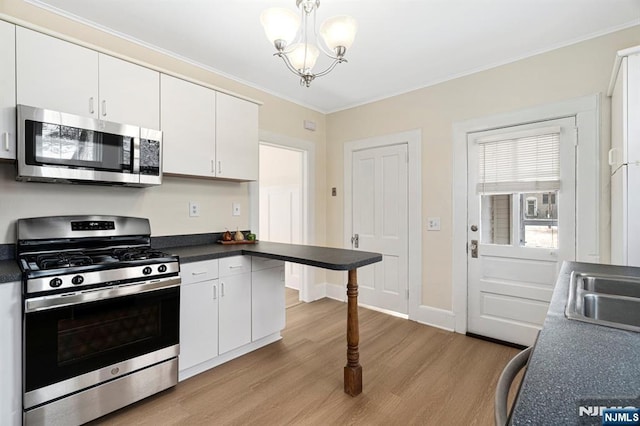 kitchen featuring stainless steel appliances, light wood-style floors, white cabinets, and crown molding