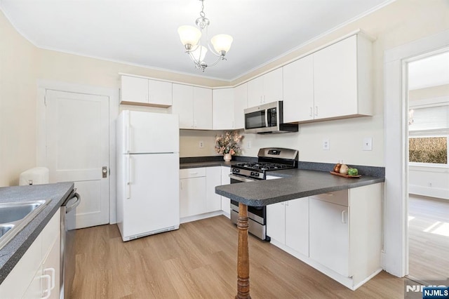 kitchen with dark countertops, light wood-style flooring, and stainless steel appliances