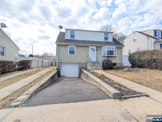 view of front of house with driveway, an attached garage, and fence