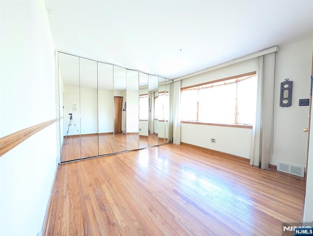 unfurnished bedroom with visible vents and wood finished floors