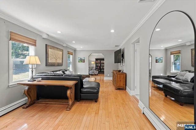 living area with light wood-style flooring, arched walkways, a wealth of natural light, and ornamental molding