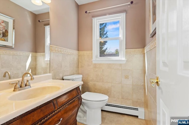 bathroom featuring tile patterned flooring, toilet, vanity, tile walls, and a baseboard radiator