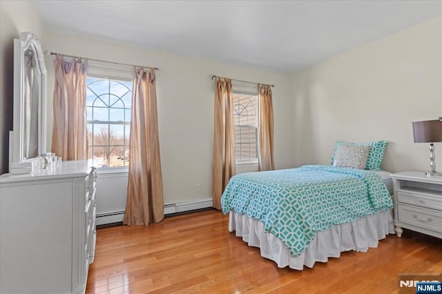 bedroom with light wood-style flooring and a baseboard radiator