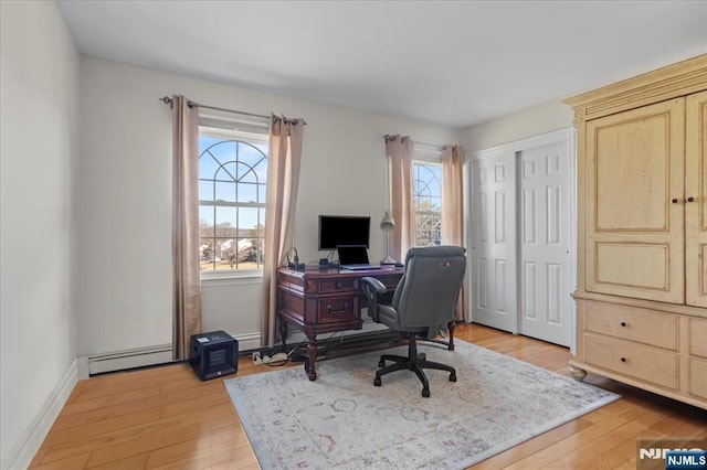 home office featuring light wood-type flooring, a baseboard radiator, and baseboards