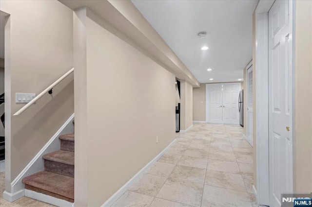 corridor featuring recessed lighting, baseboards, and stairs