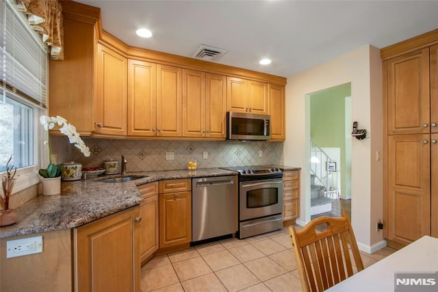 kitchen with tasteful backsplash, visible vents, appliances with stainless steel finishes, light tile patterned flooring, and a sink