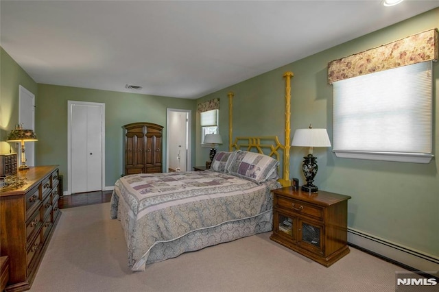 carpeted bedroom with visible vents, multiple windows, and a baseboard radiator