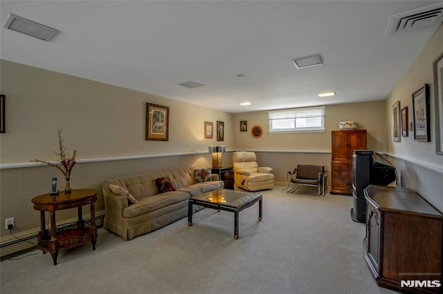 living area featuring a baseboard heating unit, carpet flooring, visible vents, and wainscoting