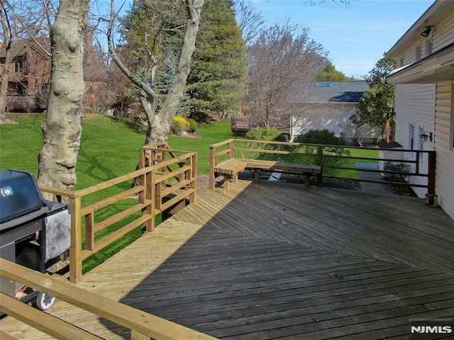 wooden terrace with area for grilling and a yard