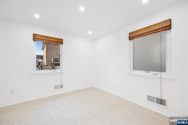 unfurnished room with recessed lighting, visible vents, and baseboards