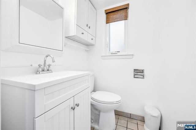 half bath with tile patterned flooring, toilet, and vanity