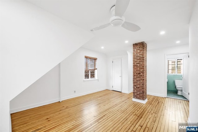 additional living space featuring baseboards, plenty of natural light, light wood-style floors, and ceiling fan