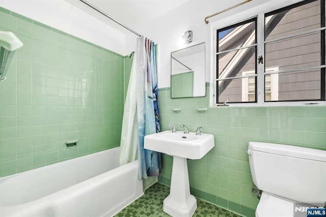 bathroom featuring toilet, tile walls, and shower / bath combo