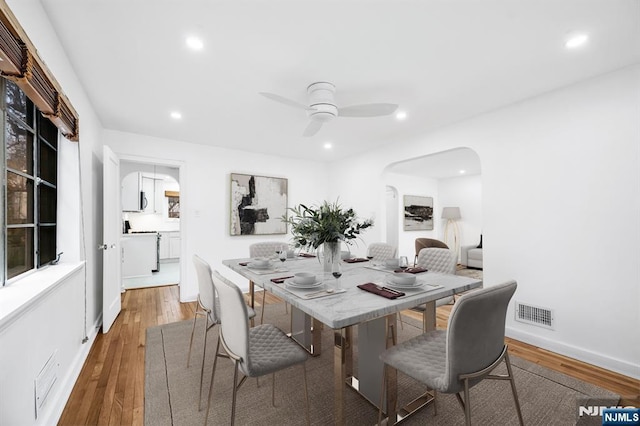 dining area with a ceiling fan, visible vents, light wood finished floors, recessed lighting, and arched walkways