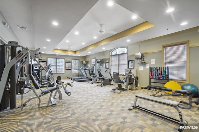 workout area featuring visible vents, ceiling fan, a tray ceiling, carpet flooring, and recessed lighting