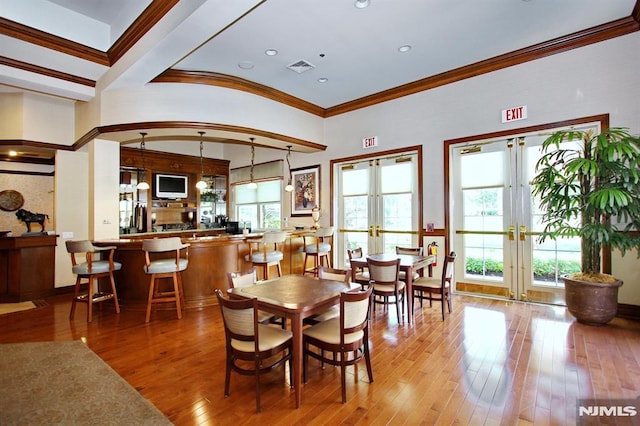 dining area featuring hardwood / wood-style flooring, french doors, visible vents, and a wealth of natural light