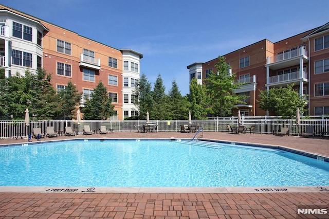 view of swimming pool featuring fence