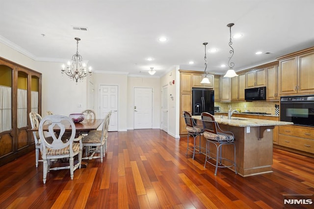 kitchen with visible vents, dark wood-type flooring, black appliances, a breakfast bar, and light stone counters