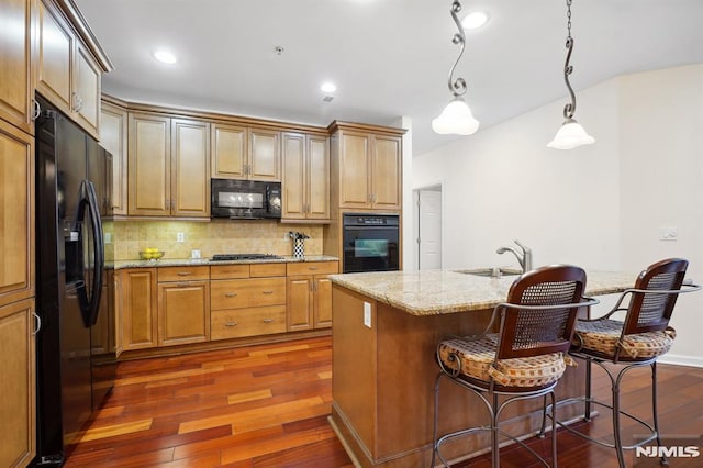 kitchen with dark wood-style floors, black appliances, tasteful backsplash, and a sink