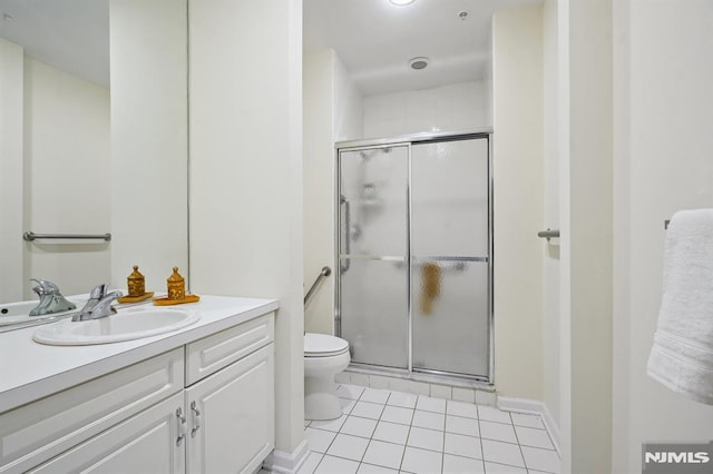 bathroom with tile patterned floors, a shower stall, toilet, and vanity