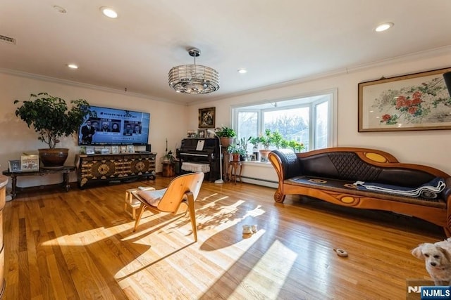 living area featuring visible vents, baseboard heating, ornamental molding, and hardwood / wood-style flooring