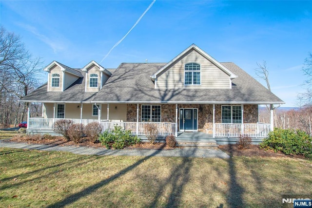 view of front of home with stone siding, a porch, a front yard, and a shingled roof