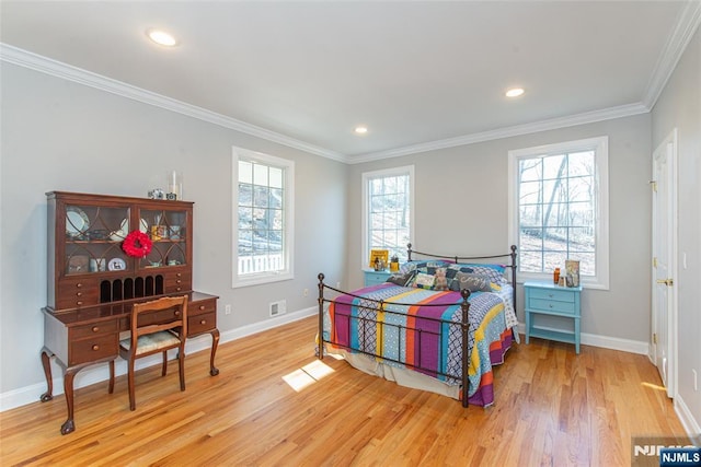 bedroom with light wood-style flooring, crown molding, and baseboards