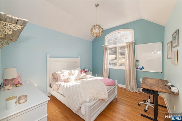 bedroom featuring a notable chandelier, light wood-style flooring, baseboards, and lofted ceiling