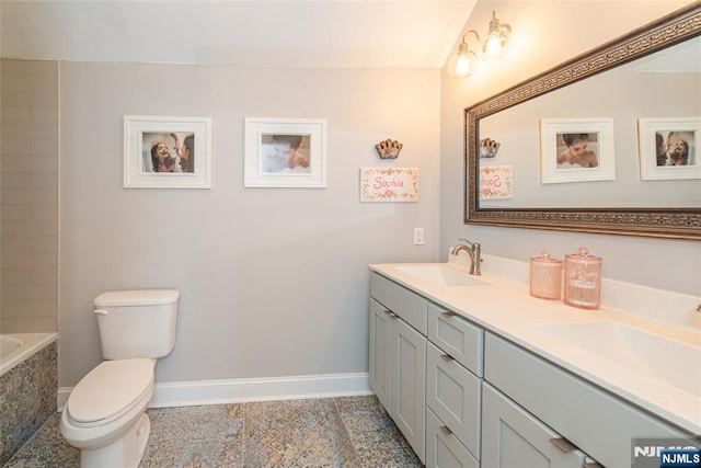 bathroom featuring double vanity, tile patterned flooring, toilet, and a sink