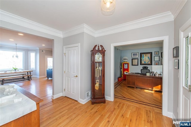 entryway featuring light wood-type flooring, baseboards, and ornamental molding