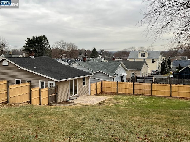 rear view of property featuring a patio area, fence, a lawn, and a residential view