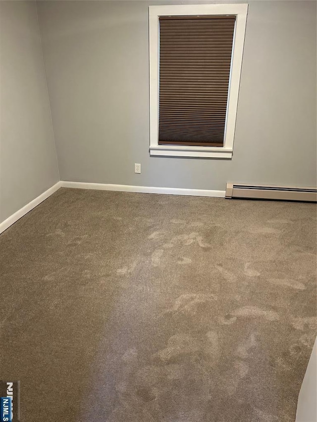 empty room with carpet flooring, baseboards, and a baseboard radiator