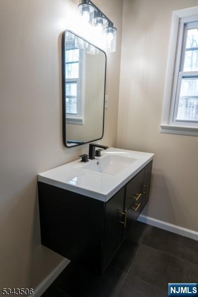 bathroom with vanity, tile patterned floors, and baseboards