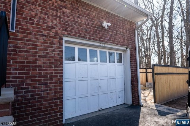 garage with driveway and fence