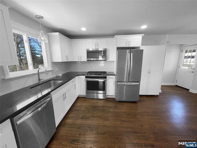 kitchen with a sink, appliances with stainless steel finishes, and white cabinetry