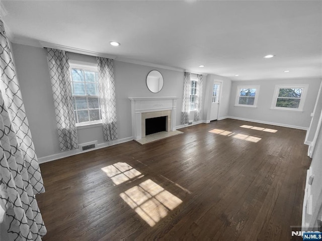 unfurnished living room featuring visible vents, baseboards, wood finished floors, and a fireplace