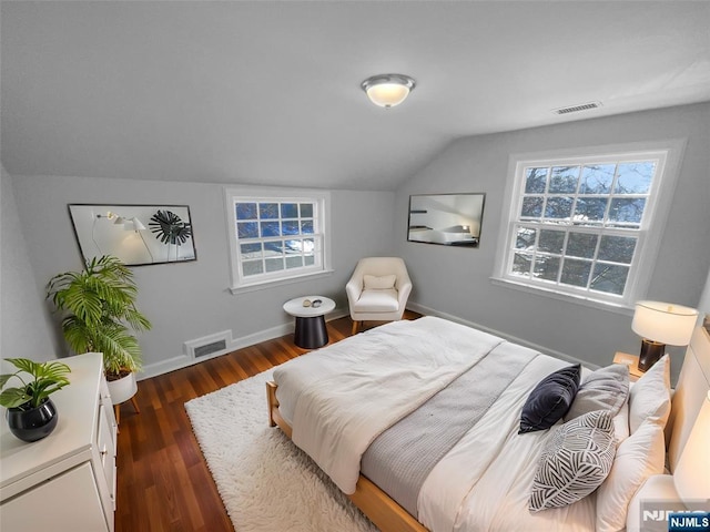 bedroom with visible vents, dark wood-type flooring, baseboards, and vaulted ceiling